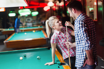 Young couple enjoying playing snooker on date