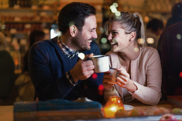 Happy couple talking at bar and having date