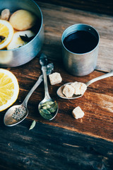 Mulled wine in rustic mug with spices and ingredients on wooden background. Top view, flat lay. Retro toned photo. Copy space for your text.