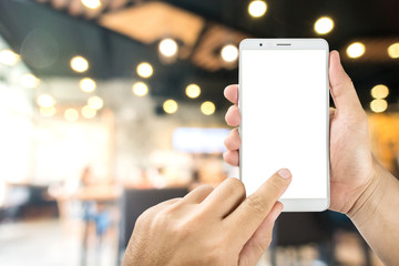 Man hand holding mobile phone with blank white screen in cafeBlurred Coffee shop.
