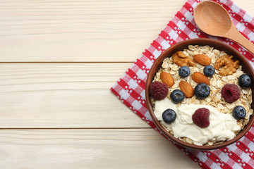 healthy breakfast. oatmeal, blueberries, raspberries and nuts on white wooden table. Top view with copy space