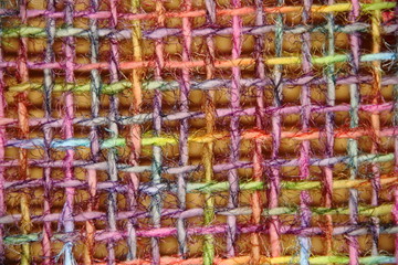 colorful yarns woven in loom frame by hand