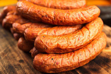 Deliciously smoked handmade Swedish Isterband sausages with natural casing. Here on a burnt wooden cutting board.