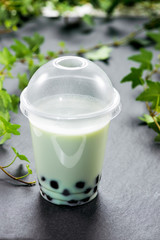 Bubble boba tea with milk and tapioca pearls in plastic cup