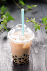 Bubble boba tea with milk and tapioca pearls in plastic cup