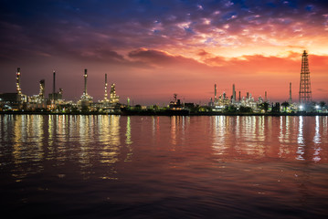 Naklejka premium Oil and gas industry - refinery at Sunrise - factory - petrochemical plant with reflection over the river