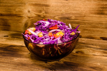 Dietary salad with the red cabbage in glass bowl on a wooden table