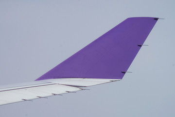 End of the right wing with small radio antenna of an airplane on the sky