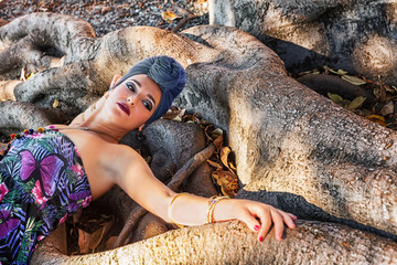 ragazza con turbante posa su albero millenario