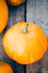 Beautiful orange pumpkin on vintage wooden background, top view, close-up, Halloween