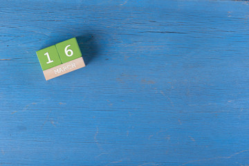 March 16, Cube calendar on wooden surface with copy space