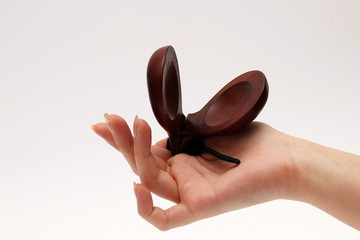 Spanish castanets in a female hand on a white background