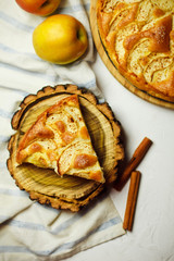 Pie with apple and cinnamon on a wooden stand. Beautiful sweet cake background