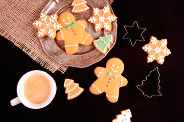 Beautiful Christmas background cookies and cap of coffee on dark background