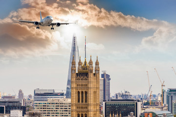 Airplane over new and old tower in London