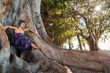ragazza con turbante posa su albero millenario