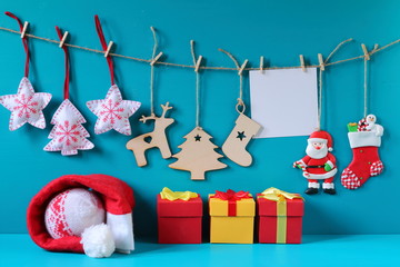 Christmas and New Year decorations made of plywood and felt hanging on the rope. Christmas and New Year decorations with card and gift boxes on a light blue wooden background.