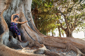 ragazza con turbante posa su albero millenario