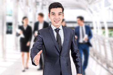 Businessman offering handshake on group of business  background