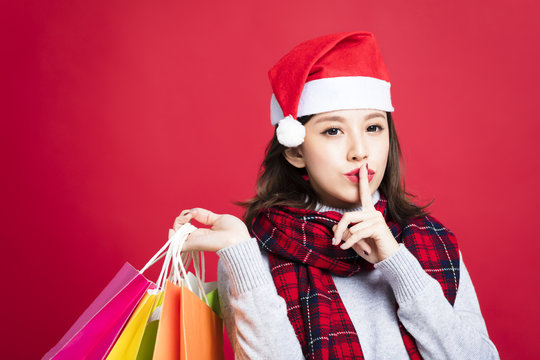 Young Woman Shopping For Christmas Gifts With Secret Gesture