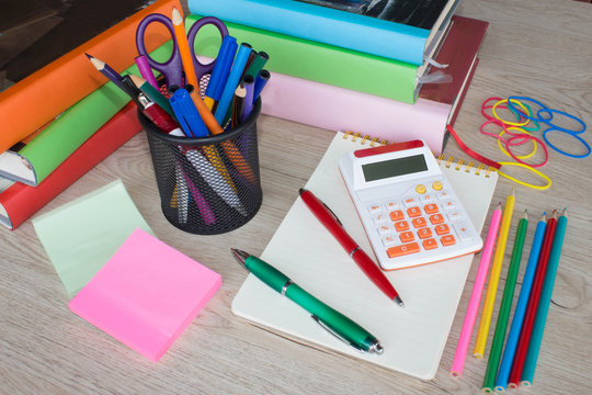 Colour pencils, calculator, notebook and office stationery at table. business accessories on table