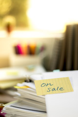 On Sale; Stack of Documents. Working or Studying at messy desk.