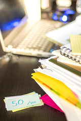 50 Percent; Stack of Documents and Laptop at working Desk.