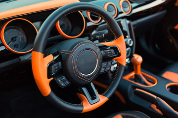 Sports car interior with orange accents.