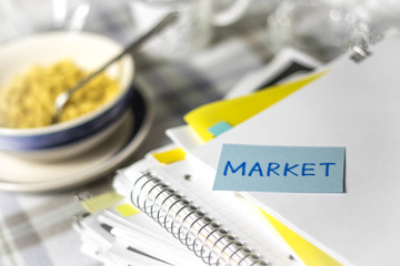 Market; Stack of Documents. Working or Studying while Eating.