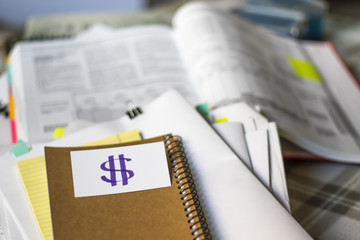 Dollar; Stack of Documents with Large Amount of Analytic Material.