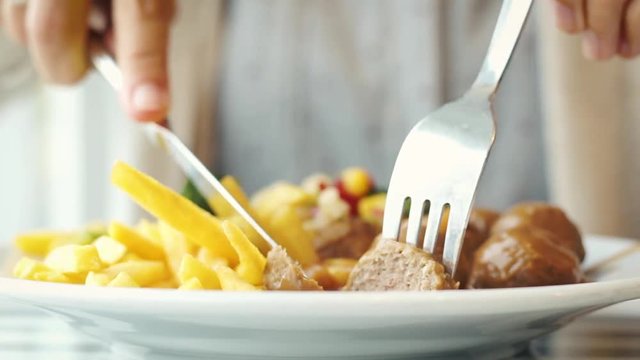 Woman Eating Meatballs And French Fries