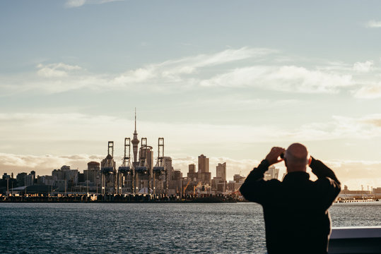 Man takes photo of Auckland skyline at sunset