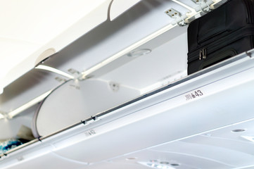 Overhead locker and compartment for baggage in airplane. Storage space for passengers bags and carry on luggage during flight. 