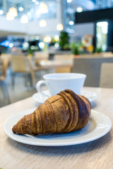 Breakfast with coffee and croissants on table