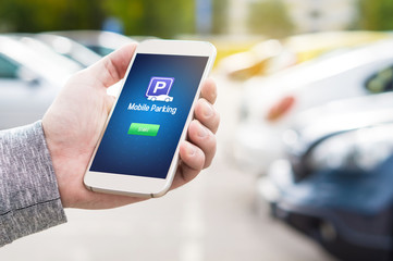Mobile parking app on smartphone screen. Man holding smart phone with car park application in hand....