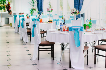 the restaurant is decorated with decorators and florists . The bows on the chairs , flowers on the tables