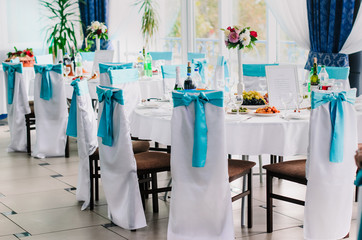 the restaurant is decorated with decorators and florists . The bows on the chairs , flowers on the tables