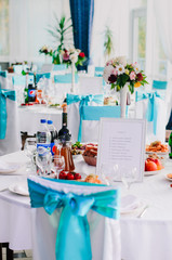 the restaurant is decorated with decorators and florists . The bows on the chairs , flowers on the tables