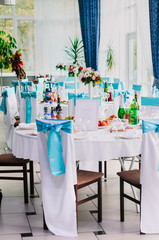 the restaurant is decorated with decorators and florists . The bows on the chairs , flowers on the tables