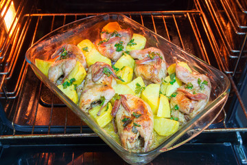 Quail meat baked in the oven. Freshly cooked quail with a side dish of new potatoes and parsley.