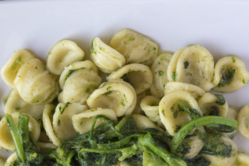 Orecchiette con le cime di rapa fatte in casa in un piatto rettangolare. Cibo pugliese.