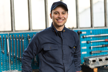 Smiling mechanic in front of his tools