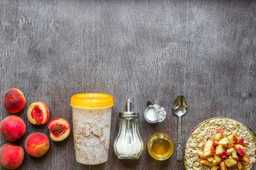 Ingredients for oatmeal on dark wooden table. Concept of healthy food. Top view, copy space.
