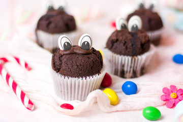 Chocolate muffins with edible eyes and colorful bonbons