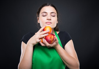 Young woman smelling some fresh and sweet nectarines