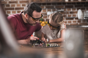 Father teaching daughter to braze