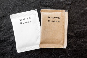 White and brown sugar bag on black background