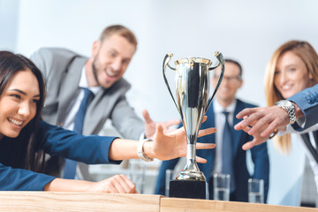 businesspeople trying to catch champion cup