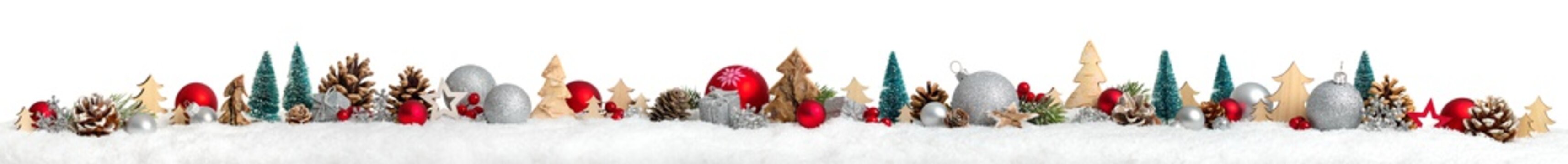 Christmas border or banner with ornaments arranged in a row on snow, extra wide and isolated on white background