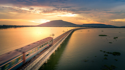 Fototapeta na wymiar The train was running at high speed through a railway bridge Over Lake Pa Sak Dam Lopburi Thailand Beautiful Sunset